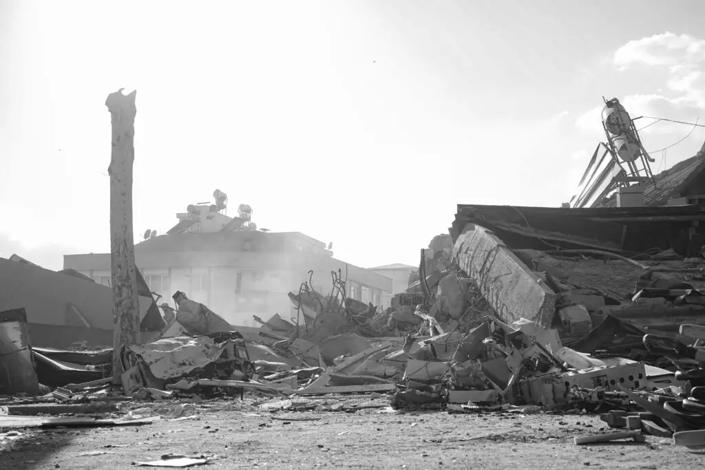 Black and white image of earthquake aftermath showing debris and ruins in urban Turkey.